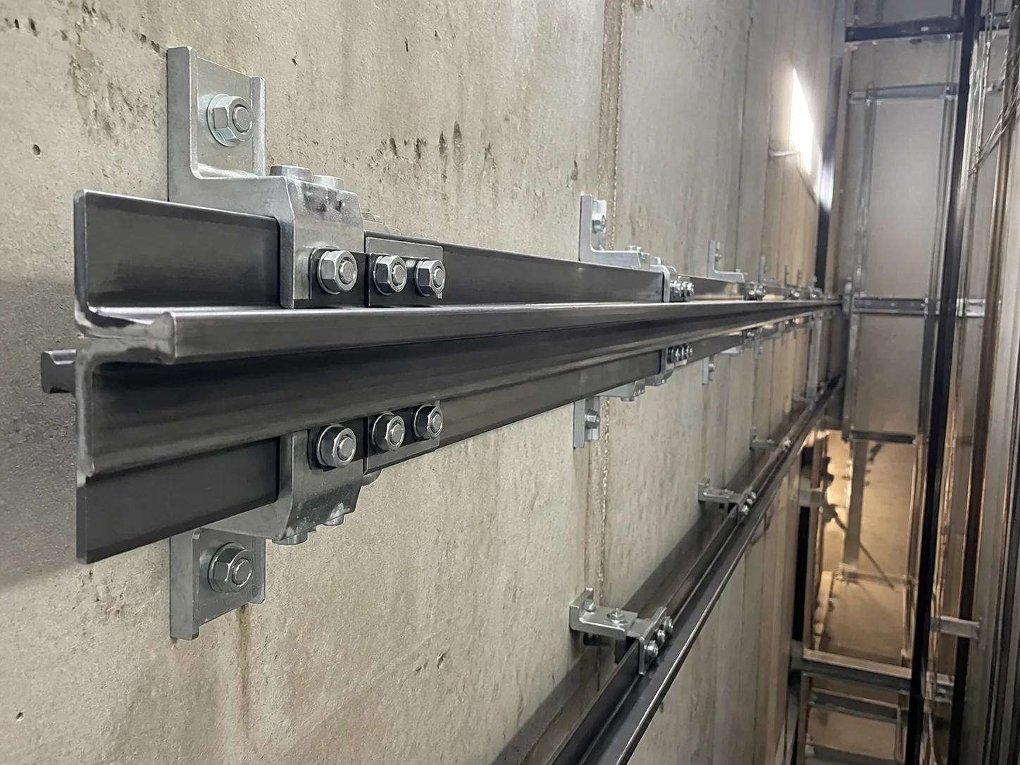 Direct-acting hydraulic elevator cylinder in a bored well beneath the pit