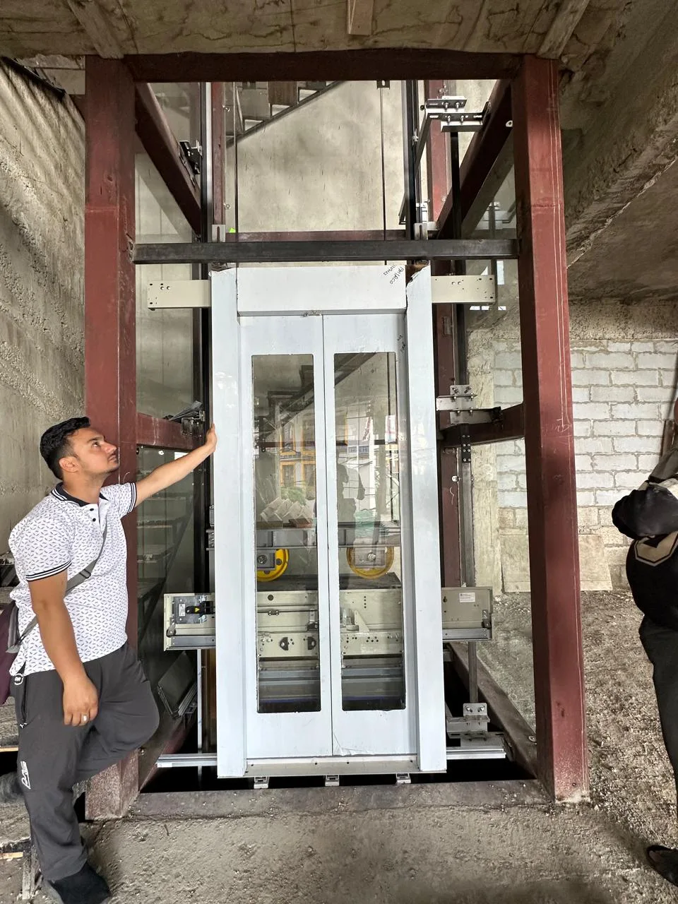 Technician fitting an elevator landing door during on-site installation