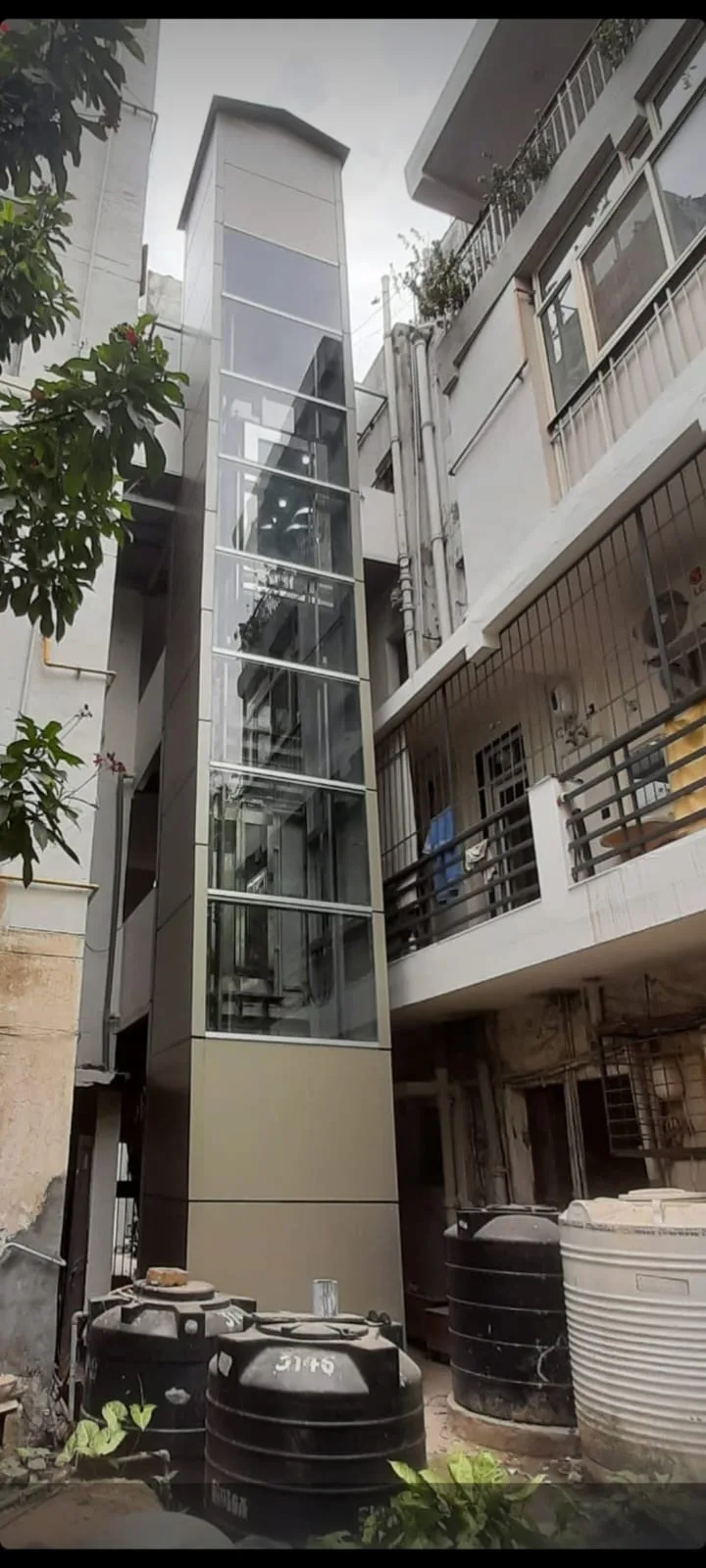External glass elevator shaft retrofit on a narrow residential building