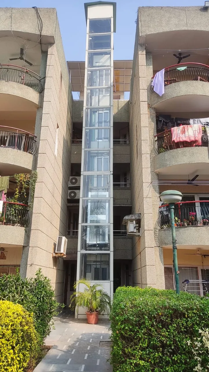 External glass elevator shaft installed between apartment blocks