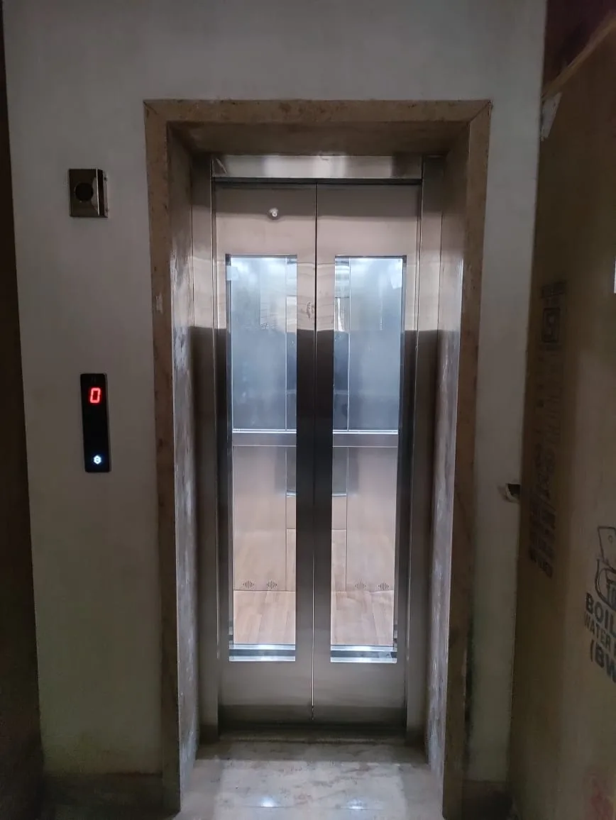 Stainless-steel elevator door with a granite surround